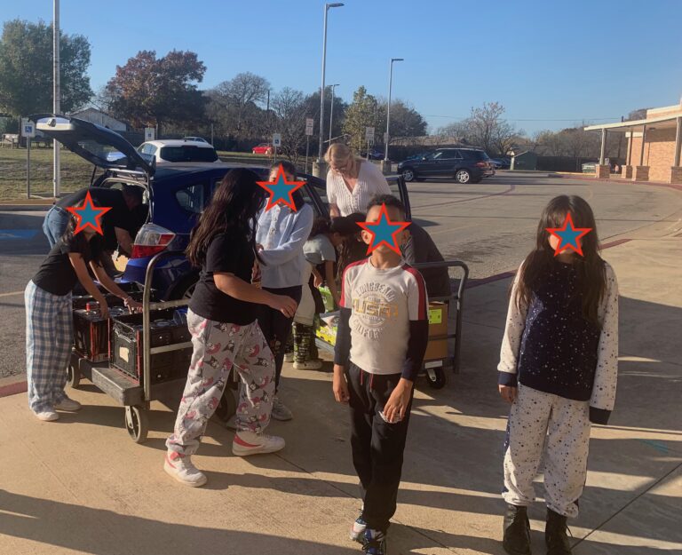 Students helping to load food items into car