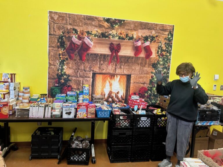 woman in front of food display with fireplace and stockings on wall