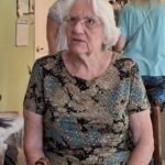 Carol a woman with white hair sitting thinking