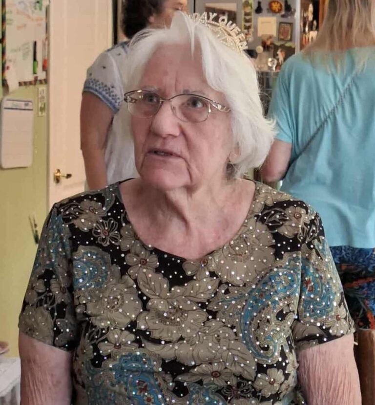woman with white hair sitting looking around
