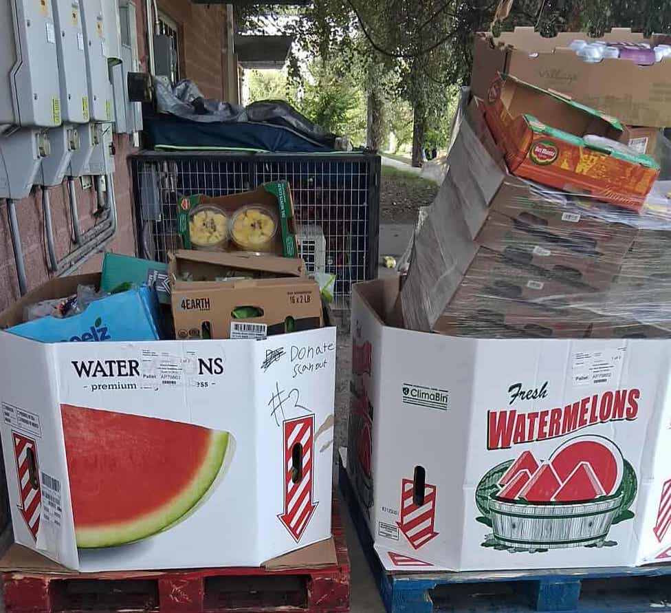 large white containers on wooden pallets stacked with boxes of food