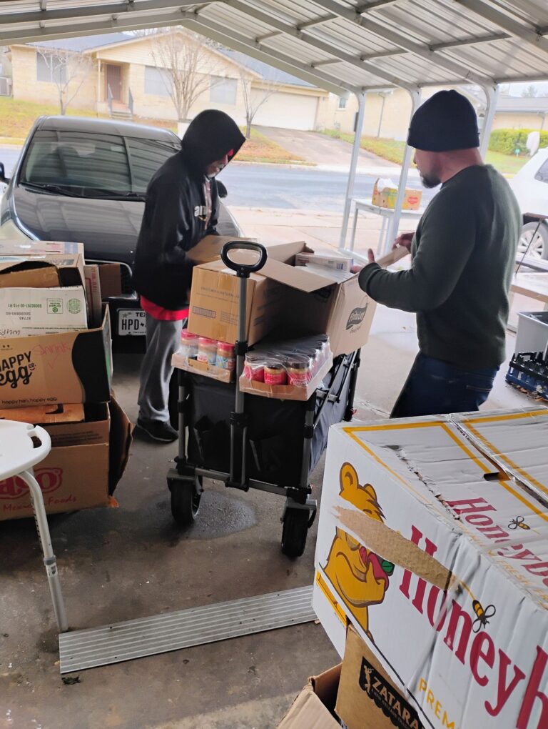 2 men in hoodies with wagon of food