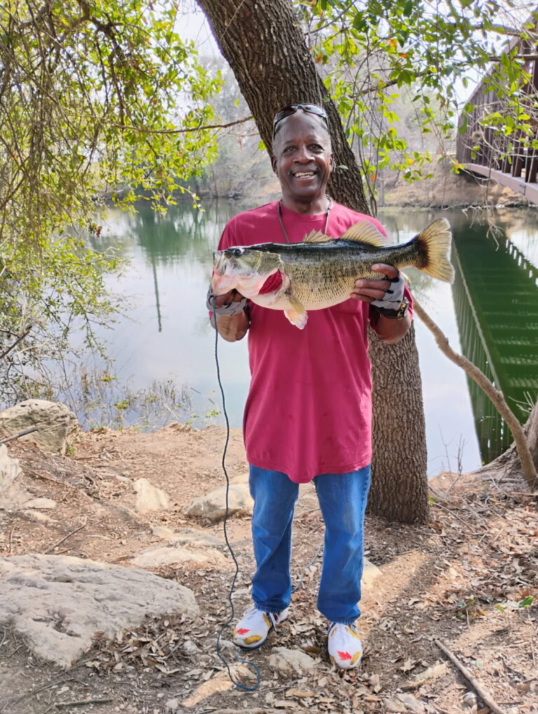 man in red shirt holding large fish